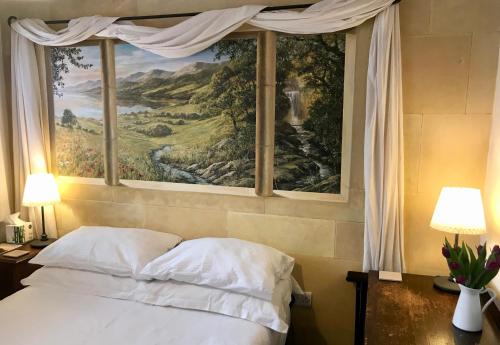 a bedroom with a large painting above a bed at Cute self-contained guest room with ensuite and private decked porch in Glastonbury in Glastonbury