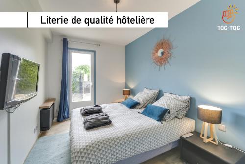 una camera da letto con un letto con pareti blu e una TV di Le Coin de Marie à deux pas du centre ville a Rambouillet