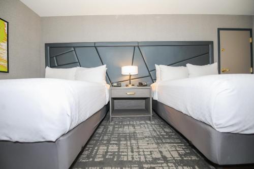 two beds in a hotel room with white sheets at Crowne Plaza Providence-Warwick (Airport) by IHG in Warwick