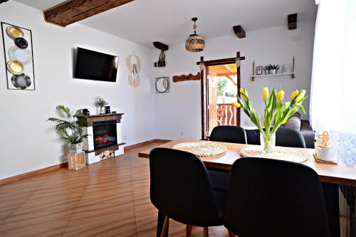 a dining room with a table and chairs and a fireplace at Drozdówka nad Soliną - Domki BOHO in Solina