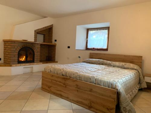 a bedroom with a bed and a fireplace at Penasa Appartamenti in Rabbi