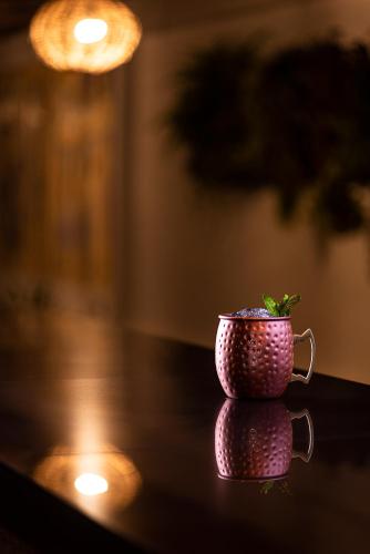 a pink cup sitting on a table with a plant in it at Hotel La Ría Playas in Playas