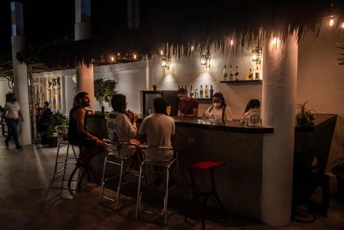a group of people sitting at a bar at night at Hotel La Ría Playas in Playas