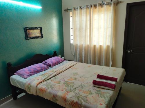 Un dormitorio con una cama y una ventana con toallas. en JMD VILLA en Vagator