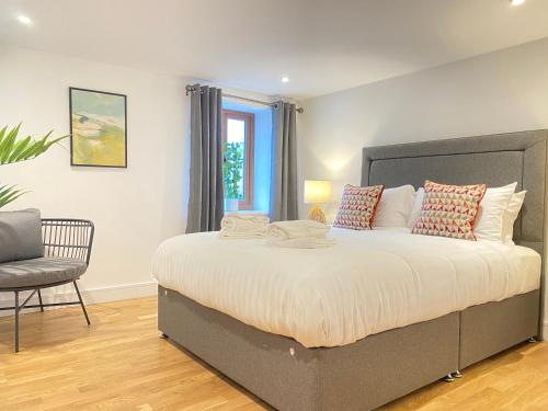 a bedroom with a large bed and a chair at Scandic House, 1 Bed Apartments, Sleeps 2, Ulverston in Ulverston
