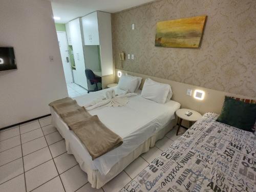 a hotel room with a large bed and a couch at Conforto e Aventura Flat Lençois Barreirinhas in Barreirinhas
