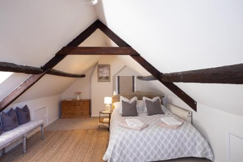 a attic bedroom with a bed and a couch at The Flat Luxurious apartment in central Bridport in Bridport