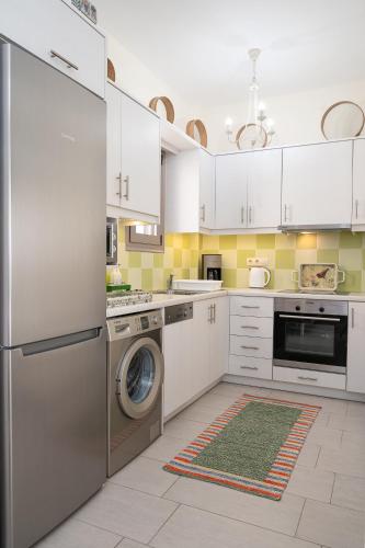 a kitchen with white cabinets and a washer and dryer at Villa Jodi in Pitsidia