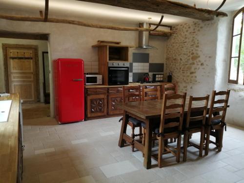 een keuken met een tafel en een rode koelkast bij Hello Pyrenees in Castelvieilh