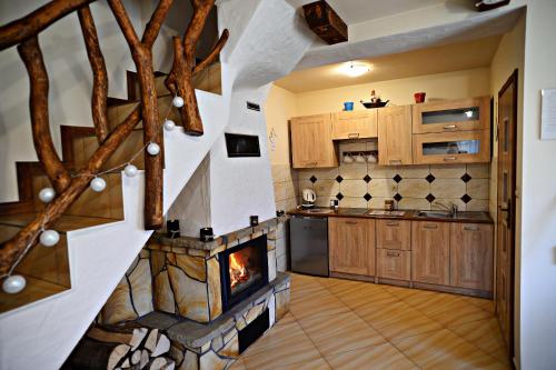 - une cuisine avec une cheminée au milieu dans l'établissement Drozdówka nad Soliną - Chata z Kominkiem, à Solina