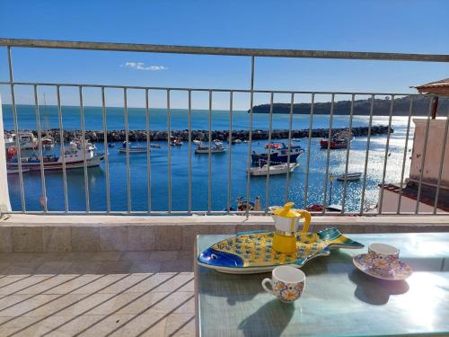a table with a tea pot on it with a view of a marina at La terrazza di Maria in Procida