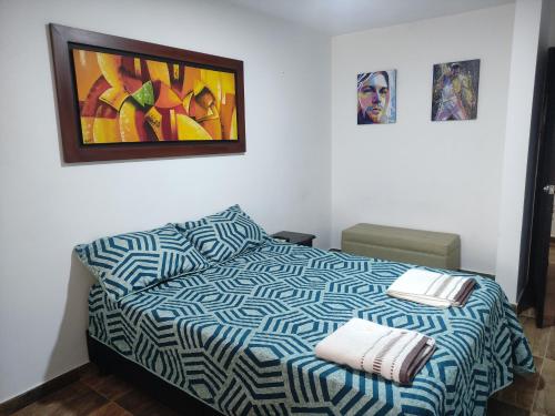 a bedroom with a bed and a painting on the wall at El buen descanso in Fusagasuga