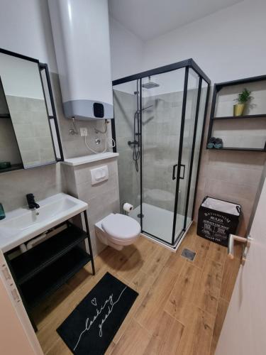 a bathroom with a shower and a toilet and a sink at Gemini Suites in Kaštela