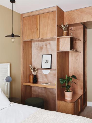 a bedroom with a bed and a wooden wall at Hotel Orphée - Orso Hotels in Paris