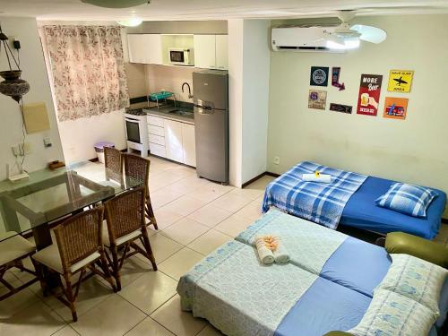 eine Küche und ein Wohnzimmer mit einem Bett und einem Tisch in der Unterkunft Apartamentos no Solar Pipa in Pipa