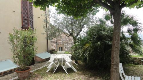a table and chairs sitting next to a tree at La Terrazza di Spello in Spello