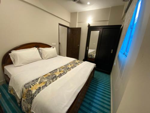 a bedroom with a large bed with white sheets at "Service Apartments Karachi" Ocean View 2 Bed Room Apt in Karachi