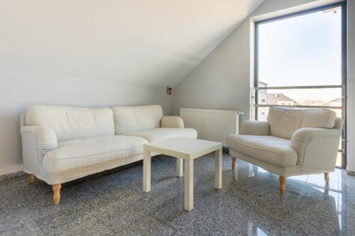 a living room with two white couches and a table at NoclegiJarocin Bed & Breakfast in Jarocin