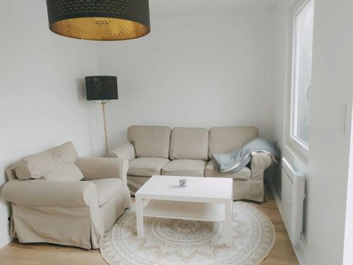 a living room with a couch and a coffee table at "Mont 1er Pas" proche Mont St Michel in Pontorson