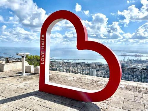 a large red mirror sitting on top of a building at Paris Square Apartments Downtown in Haifa