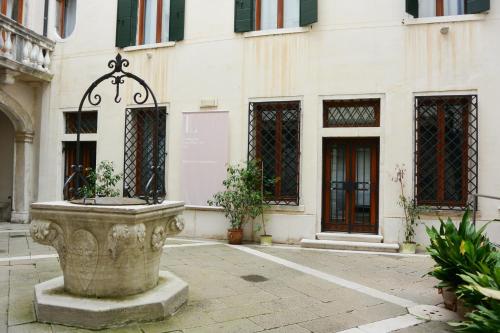 a stone fountain in front of a building at Foresteria Levi in Venice