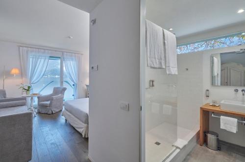 łazienka z prysznicem, łóżkiem i umywalką w obiekcie Hotel Villa Aurora w mieście Lezzeno