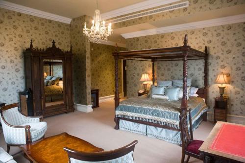 una camera con letto e lampadario a braccio di Kilronan Castle Hotel & Spa a Ballyfarnon