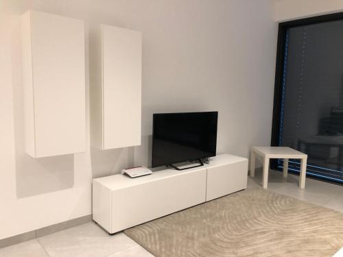 a living room with a tv on a white cabinet at Garou in Luxembourg