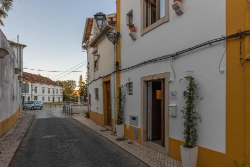 an empty street in a town with yellow and white buildings at Love Tomar in Tomar