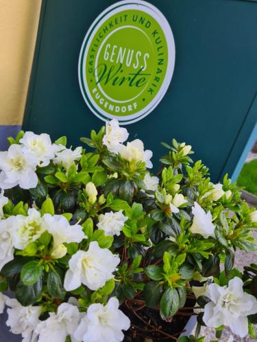 a sign for a green and white plant with white flowers at Gasthof zur Strass in Eugendorf