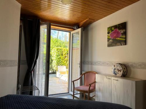 - une chambre avec un lit et une porte coulissante en verre dans l'établissement Petites maisons avec piscine, à Sarlat-la-Canéda