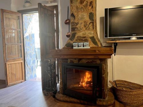 a living room with a fireplace with a television on top at Casa La Fuente in Jabugo