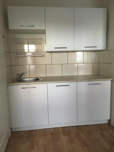 a kitchen with white cabinets and a sink at Pokoje u Asi in Augustów