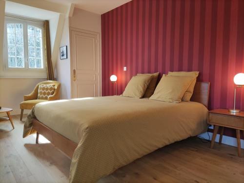 a bedroom with a large bed with red walls at chambre SIXTIES in Lingèvres