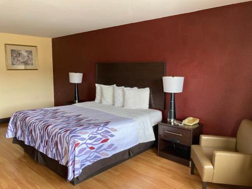 a hotel room with a bed and a chair at Red Roof Inn & Suites Cleveland, TN in Cleveland