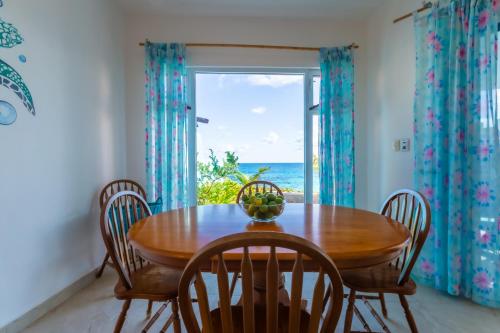 a dining room with a table and chairs and a window at Casa Cielo 2 Bedroom Oceanfront Villa in Isla Mujeres