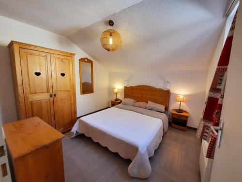 um quarto com uma grande cama branca num quarto em T2/3 6pers & pied des pistes & piscine chauffée em Vars
