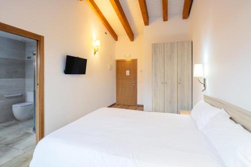 a bedroom with a white bed and a bathroom at O Trancallo in Viana do Bolo