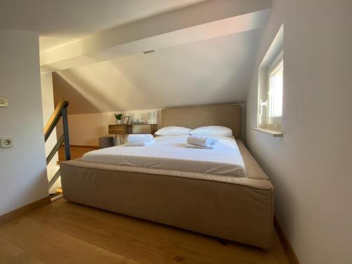 a bedroom with a large bed in a attic at Apartmani Lozić in Baška Voda