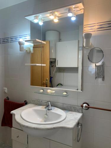 a bathroom with a sink and a mirror at Apartamento en primerísima línea de playa con espectaculares vistas Netflix, Prime y Disney in Oropesa del Mar