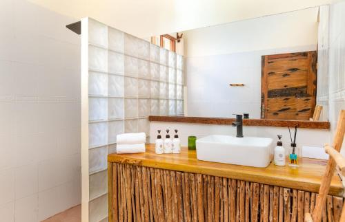 uma casa de banho com um lavatório e um espelho em Marafiki Beach Hotel & SPA em Matemwe