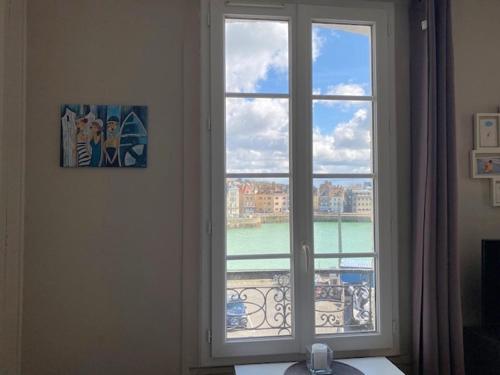 a window in a room with a view of the water at VUE PORT "Le Studio du Bout du Quai" 2pers Dieppe in Dieppe