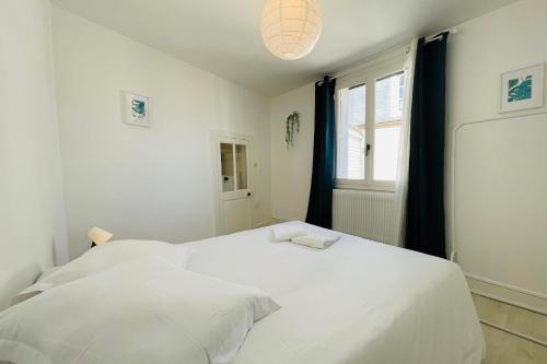 un lit blanc dans une chambre avec une fenêtre dans l'établissement ENTRE 2 RIVES Échappée Amboisienne avec sauna partagé, à Amboise