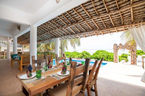 a dining area with a table and chairs at Marafiki Beach Hotel & SPA in Matemwe
