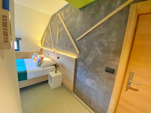 a small room with a bed and a staircase at 16 Lakes Hotel in Grabovac
