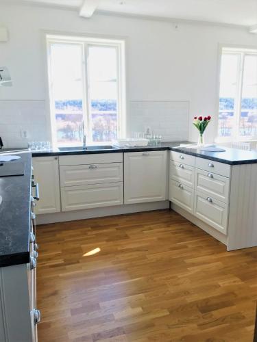 a kitchen with white cabinets and black counter tops at Kastellegården Skanskullen in Kungälv