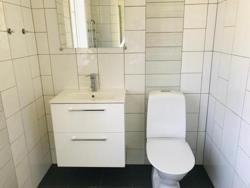 La salle de bains est pourvue de toilettes blanches et d'un lavabo. dans l'établissement Kastellegården Skanskullen, à Kungälv