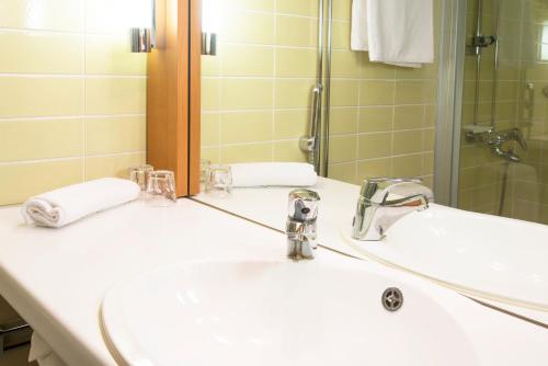 a bathroom with two sinks and a mirror at Scandic Kemi in Kemi