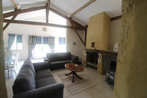 a living room with a couch and a fireplace at La Villa a Bel-Endroit in Marciac