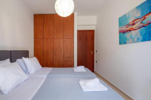 a bedroom with a bed with two towels on it at Grey House "by Checkin" in Karteros